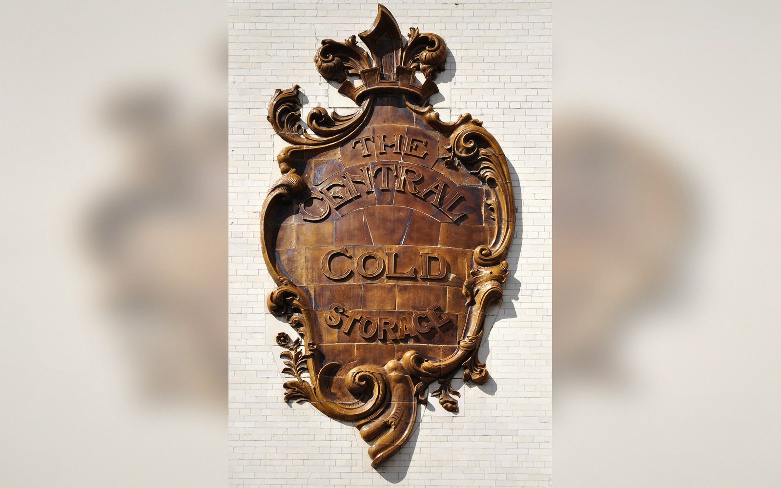 Ornate bronze plaque reading "The Central Cold Storage" mounted on a brick wall